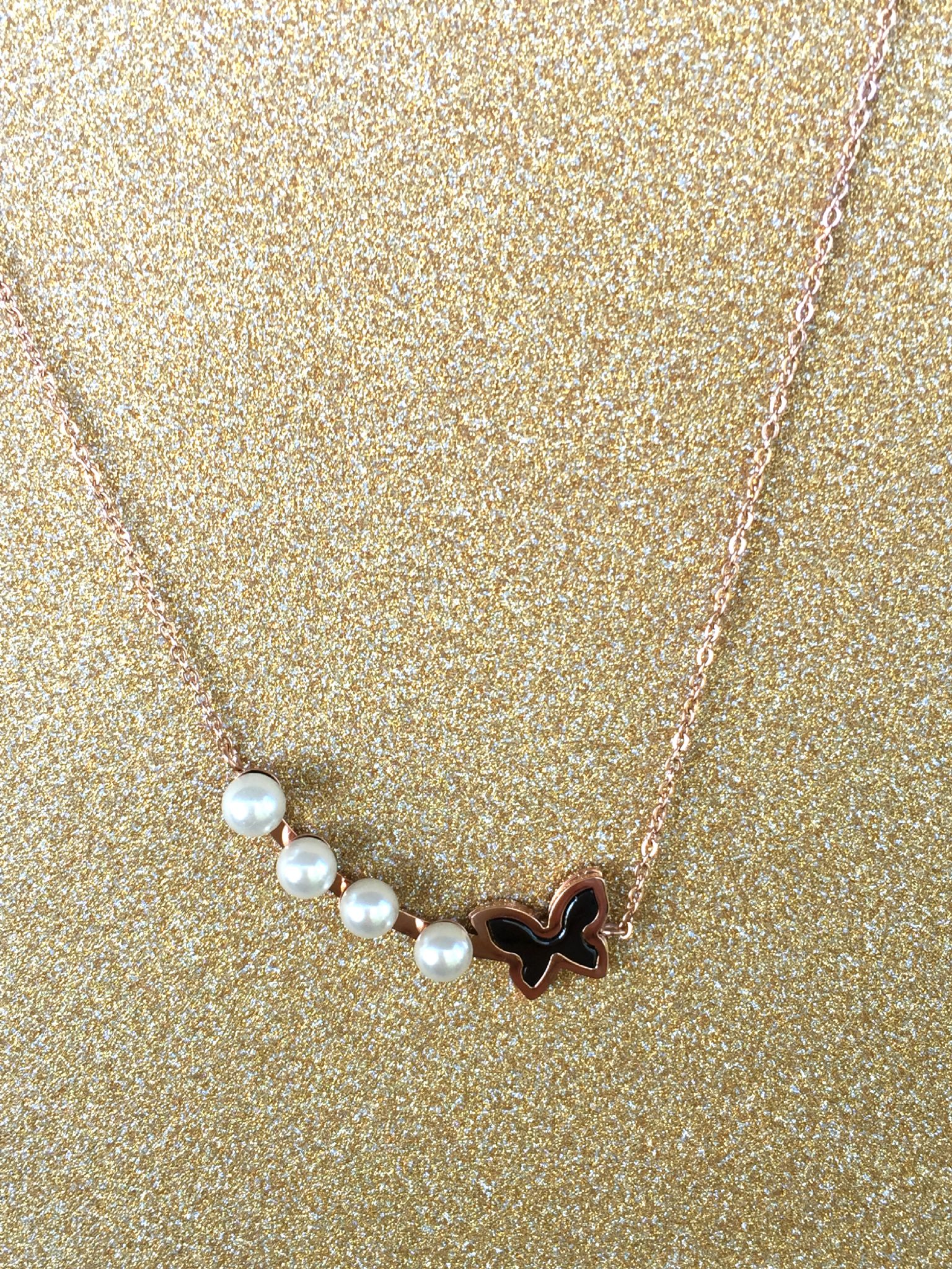 A beautiful butterfly pendant made of mother of pearl and emblazoned with small glittering crystals on a gold metal base. J020010